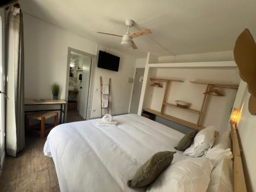 休达德亚Balear Hotel的卧室配有一张白色大床和吊扇