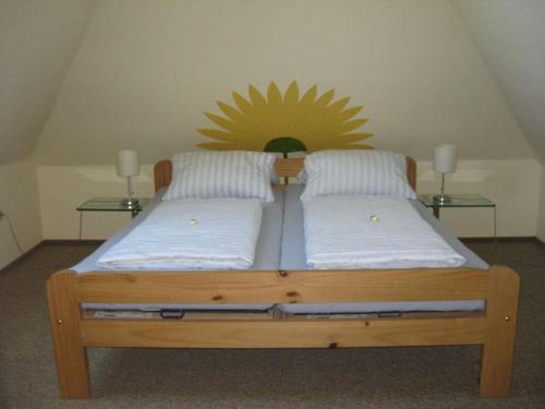 海利根港Holiday apartment for the Franck family的一张带两个枕头的木床和墙上的阳光