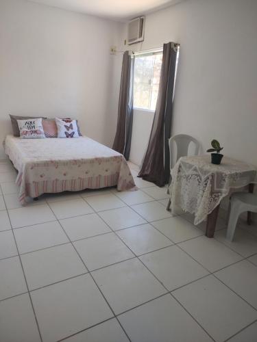 德奥多鲁元帅镇Hostel da Prainha的一间卧室配有一张床、一张桌子和一个窗户。