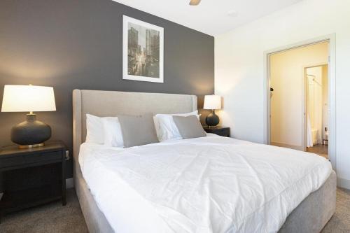堪萨斯城Landing Modern Apartment with Amazing Amenities ID8348X93的卧室配有一张白色大床和两盏灯。