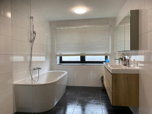 阿纳姆Luxe Appartement Marc的白色的浴室设有浴缸和水槽。