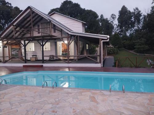 PiraquaraChacara Recanto Vale do Luar的房屋前有游泳池的房子