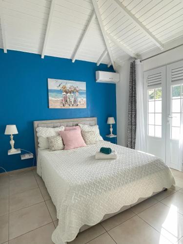圣弗朗索瓦Résidence Subtropicale的一间卧室设有一张蓝色墙壁的大床