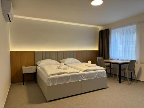 克伦特尼采Comfort Pálava, Penzion & Restaurant的酒店客房配有一张床铺和一张桌子。