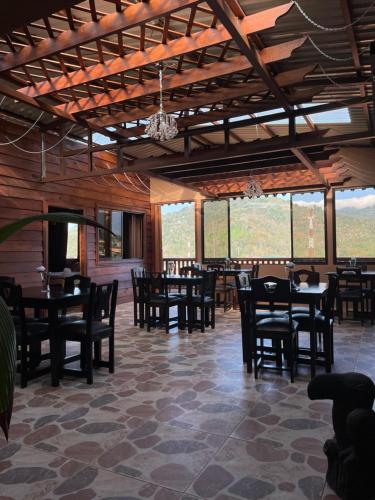 迦太基Dreams Lodge Orosi的用餐室设有桌椅和窗户。