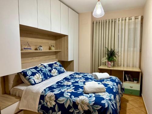 地拉那SkyView Oasis Premium Apartment的一间卧室配有一张带蓝白色毯子的床