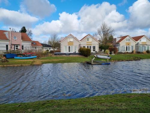 玛库姆Prachtige vakantievilla aan IJsselmeer Makkum的一群水中装有船的房屋