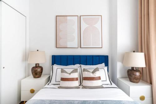 纽约91-1D 3BR 2baths Duplex with a Private Back yard - GYM的一间卧室配有一张带两盏灯的蓝色和白色的床。