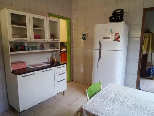 波多韦柳CASA MJ HOSPEDAGEM的厨房配有白色冰箱和桌子