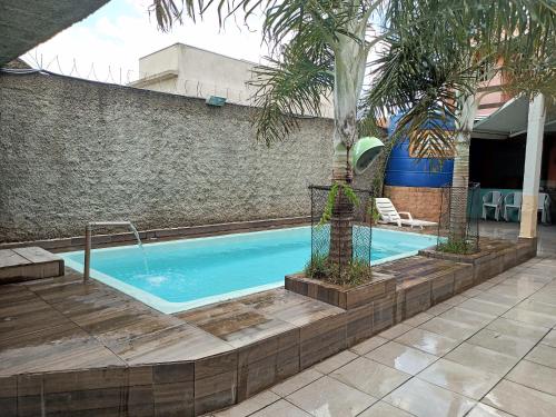 索罗卡巴Espaço com piscina的一座游泳池,旁边是一座棕榈树