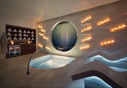拉斯维加斯Corner Suite at Vdara Hotel and Spa的一间带镜子和灯的浴缸的浴室