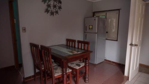 安加罗阿Petero Atamu的厨房配有桌椅和冰箱。