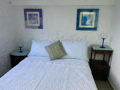 San MartínLa Casona Llanera的一间卧室配有一张白色的床,桌子上配有两盏灯