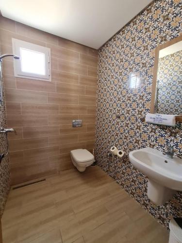 TemlaleMusk de djerba suite aziz avec piscine的一间带卫生间、水槽和镜子的浴室