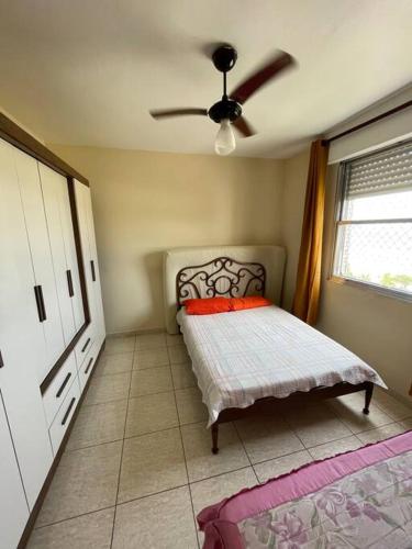 圣维森特岛Apartamento com pé na areia的一间卧室配有一张床和吊扇