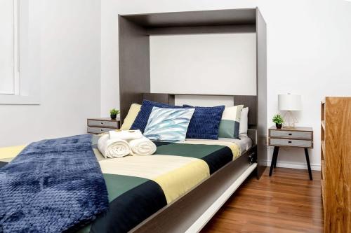 多伦多Kensington Market Apartment的一间卧室配有一张带蓝白色床单的大床
