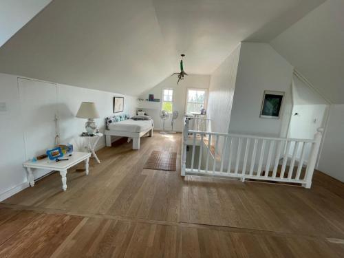 罗克桑德Bahamian Farm House的大房间设有白色的墙壁和木地板