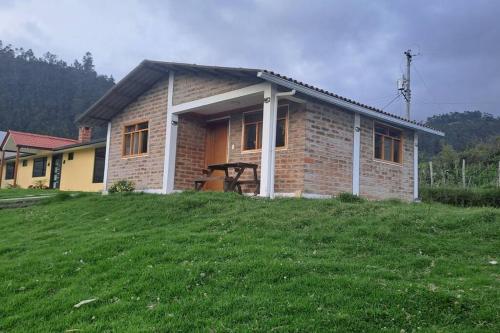 奥塔瓦洛Cozy cabin in the countryside Otavalo Learning的草山上的小砖房子