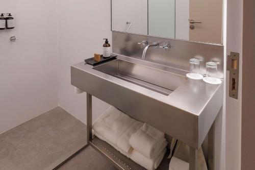 门多萨Hualta Hotel Mendoza, Curio Collection by Hilton的浴室配有水槽和毛巾。