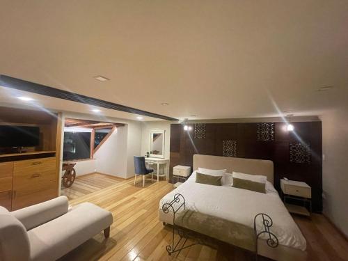 昆卡Hotel Ensueños的一间卧室设有一张床和一间客厅。