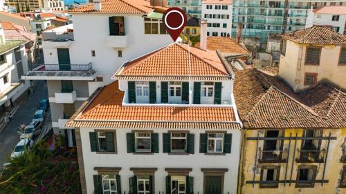 丰沙尔Alojamento Local Trigal的享有白色建筑的顶部景色,设有红色屋顶