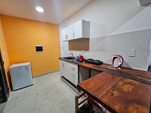 卡法亚特La Emilia的厨房配有白色橱柜和木制台面
