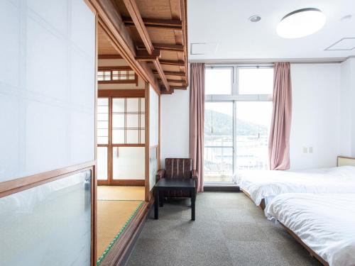萨摩川内市HOTEL Tsuru Sendai的酒店客房,配有两张床和椅子