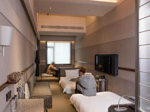 深圳深圳NOA诺亚酒店的坐在酒店房间,带两张床的人