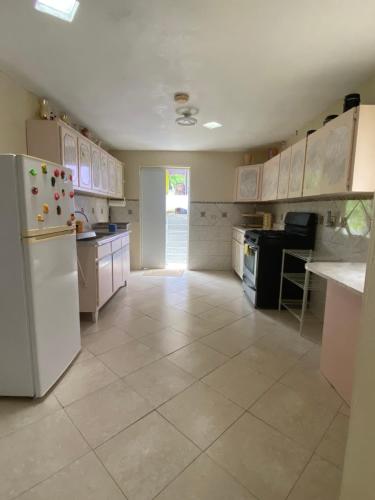 OrocovisApartamentovistadelrio2的厨房配有白色冰箱,铺有瓷砖地板。