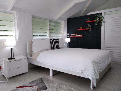 尤姆迪欧门帝游艇俱乐部住宿加早餐旅馆的卧室配有白色的床和黑色墙壁