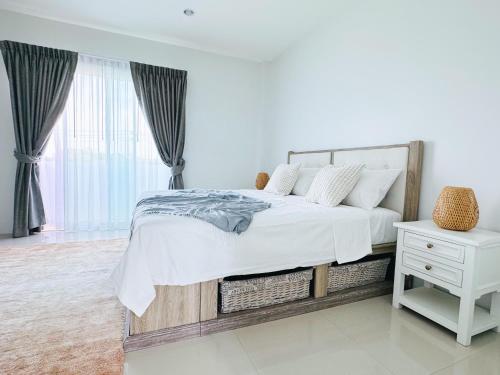 攀瓦海滩White Castle的白色卧室设有一张大床和一张白色桌子。