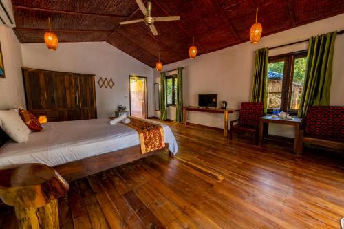 富国Dugong Resort Phu Quoc的一间卧室配有一张床,铺有木地板