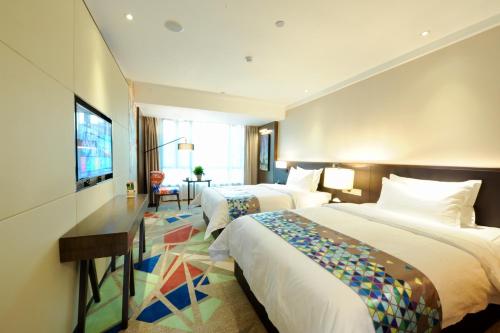广州潮漫酒店（广州火车站三元里地铁站店）的酒店客房设有两张床和一台平面电视。