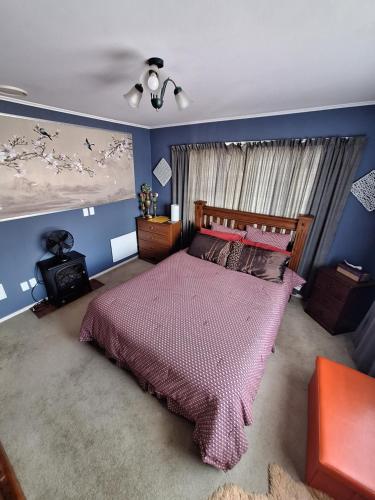 Haywardsrooms with a view的一间卧室配有一张大床和紫色床罩