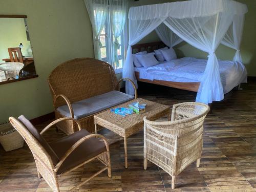 姆托瓦姆布Mwi Village House的卧室配有一张床和一张桌子及椅子