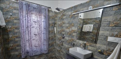 考萨尼Uttarakhand resort的浴室设有紫色的浴帘和水槽