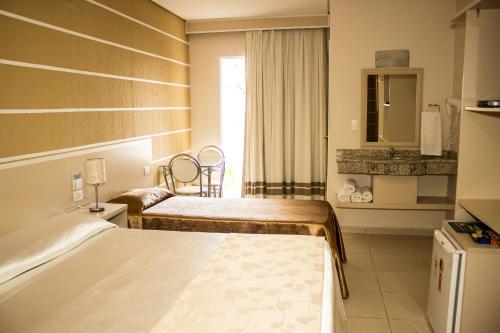 伊瓜苏Pousada Cataratas的酒店客房设有两张床和窗户。