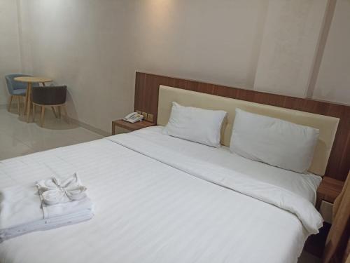 巴淡岛中心Hotel Morena Batam的卧室配有白色的床,上面有弓