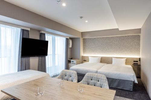 东京涩谷东急住宿酒店的酒店客房设有两张床和一台平面电视。