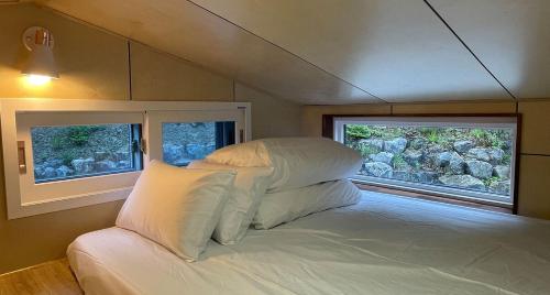 JecheonStarium Jecheon的小型客房的一张床位,设有两个窗户