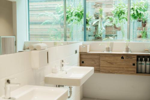 台东路得行旅台东2馆的白色的浴室设有两个盥洗盆和镜子