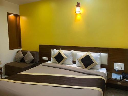 新德里Svaruchi Inn的一间卧室设有一张床和黄色的墙壁