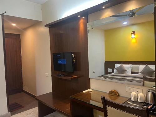新德里Svaruchi Inn的客房设有一张床、一张书桌和电视