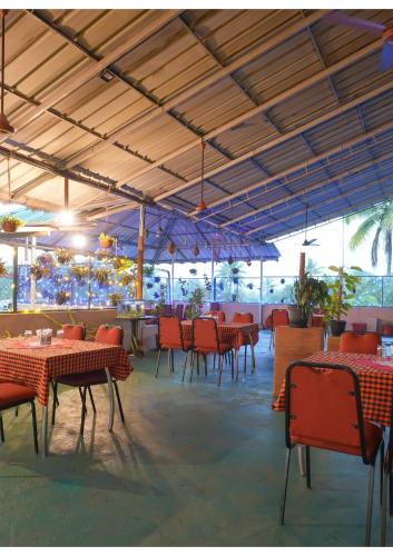 KāladiHotel Aramana的餐厅设有红色的桌椅和天花板。
