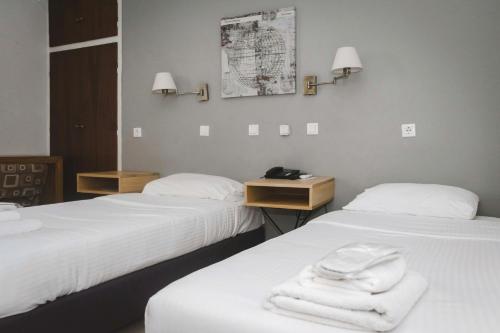 美西尼Messini Hotel的两张位于酒店客房的床,配有毛巾