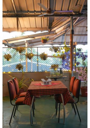 KāladiHotel Aramana的用餐室配有桌椅和植物