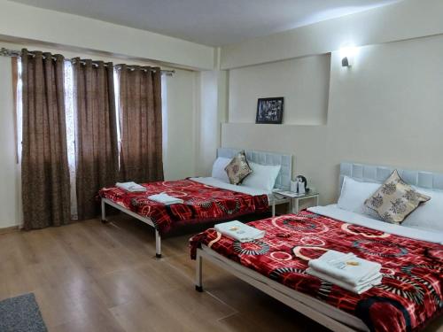 大吉岭New Maya Residency的酒店客房设有两张床和窗户。