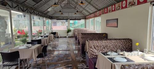 大吉岭New Maya Residency的餐厅内带桌椅的用餐室