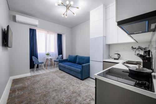 阿拉木图Апартаменты на Гагарина的厨房以及带蓝色沙发的客厅。