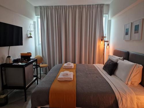 尼科西亚MARTIN Nicosia City Suites的酒店客房,配有带毛巾的床